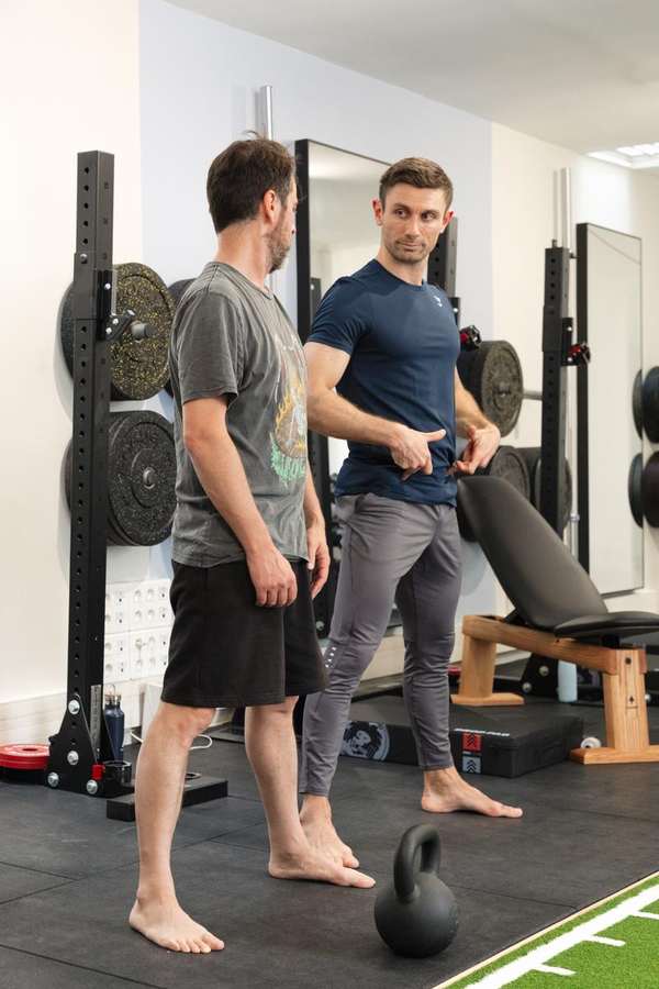 A coach working with members in Semi-Private Coaching