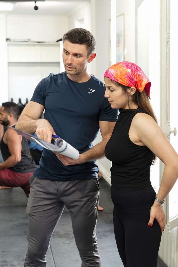 Un coach présente son programme individuel à une membre