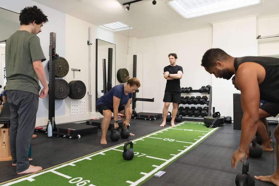 Members training with kettlebells on the track